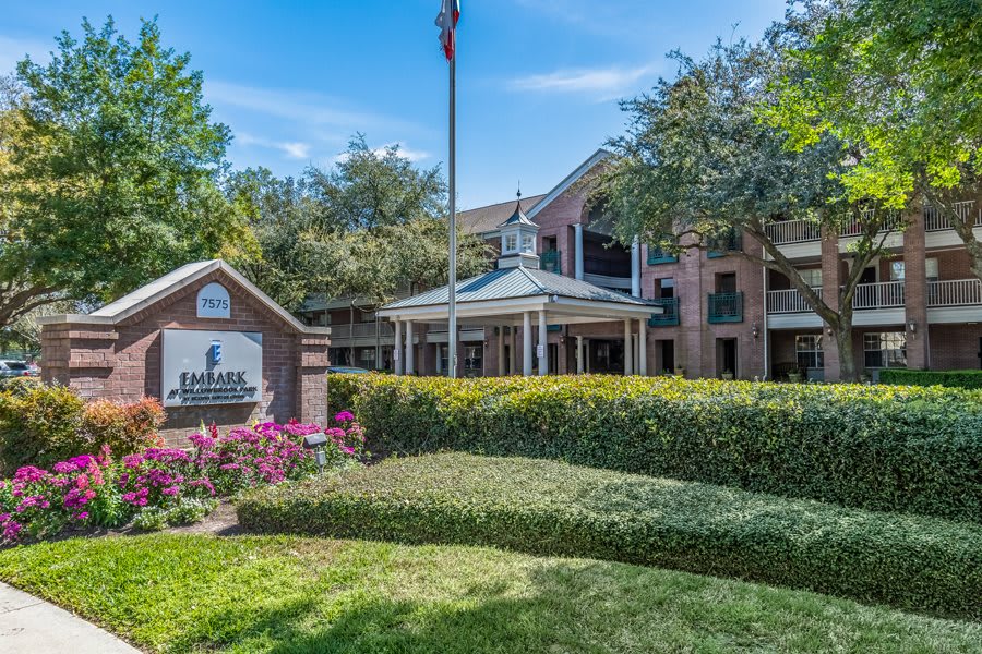 A well-maintained hotel exterior with landscaped gardens and a prominent sign.