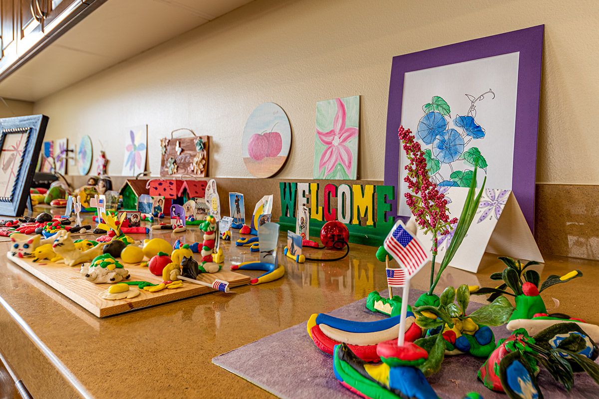 A vibrant display of handmade arts and crafts featuring a welcome sign.