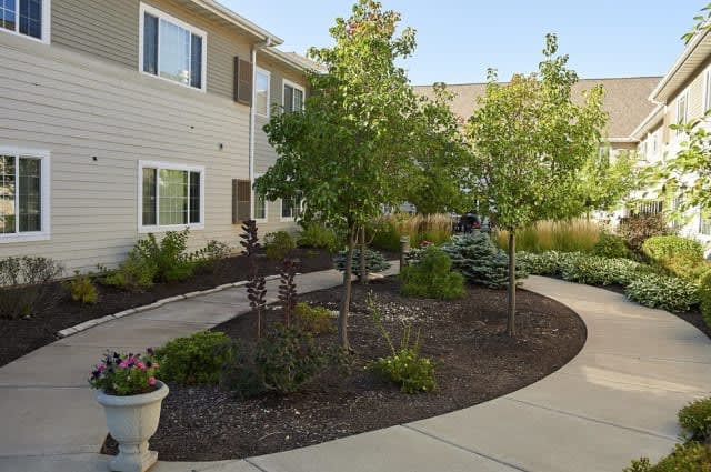A well-landscaped apartment complex with a garden and pathway.