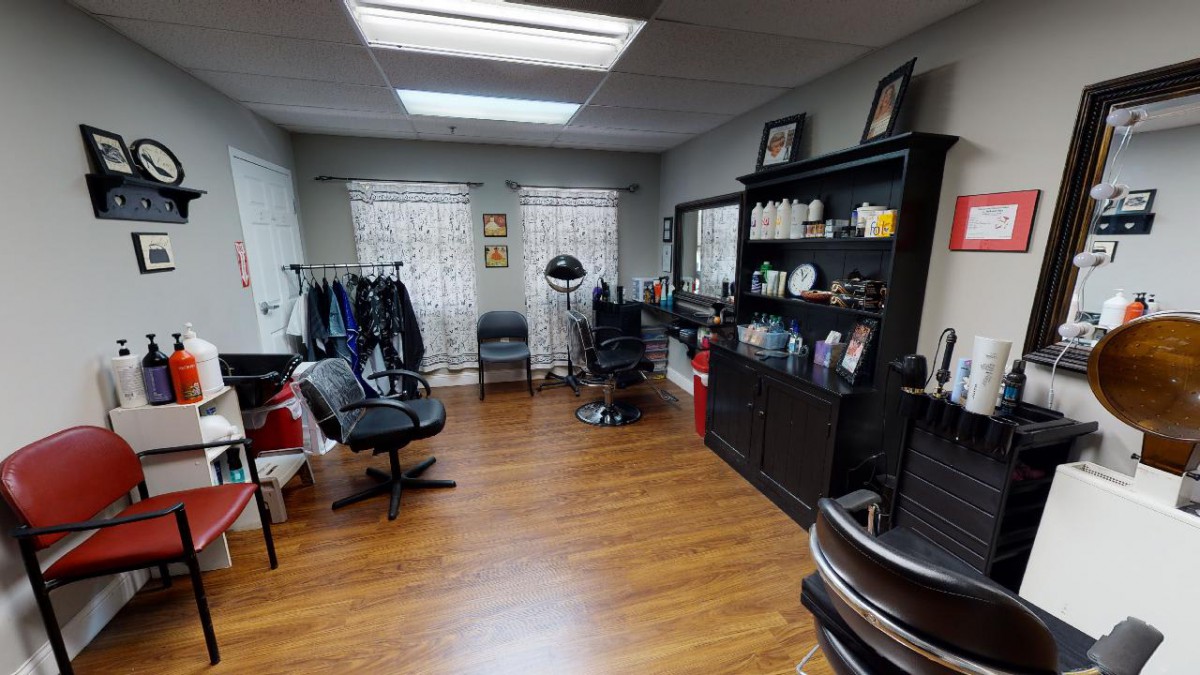 A cozy hair salon with chairs, a mirror, and various hair products on display.