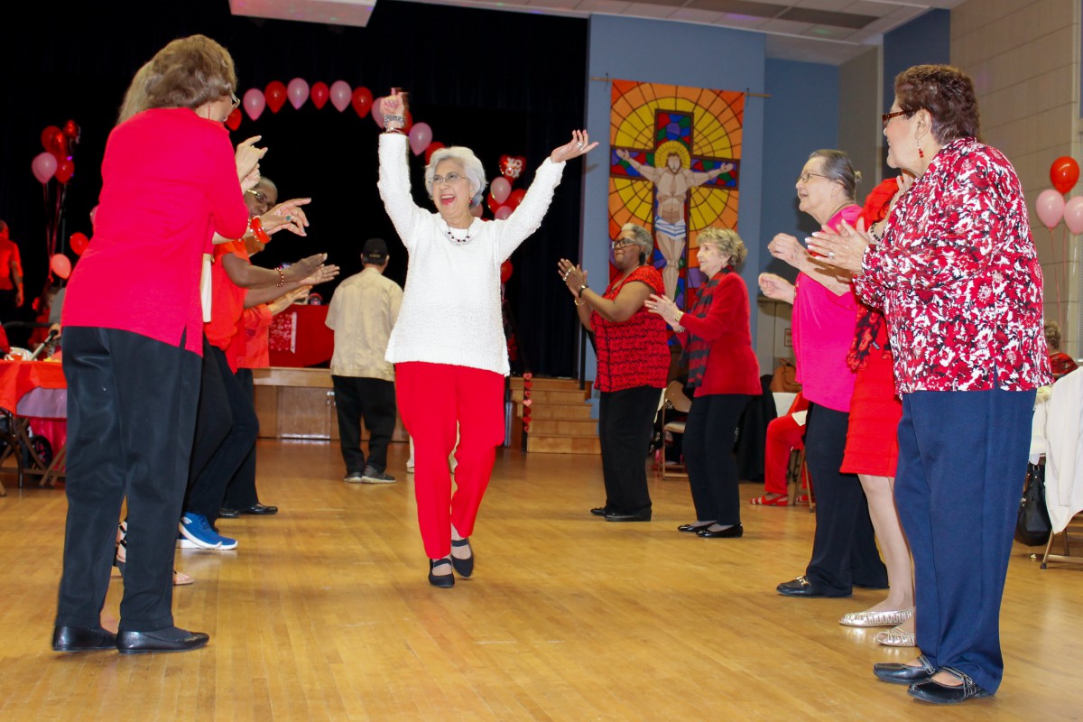 A group of seniors enjoying a lively dance session indoors.