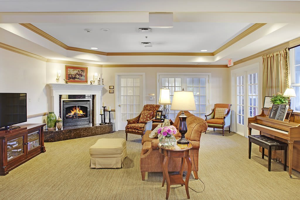 A cozy living room with a fireplace, comfortable seating, and warm lighting.