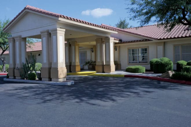 A building entrance with columns and a driveway.