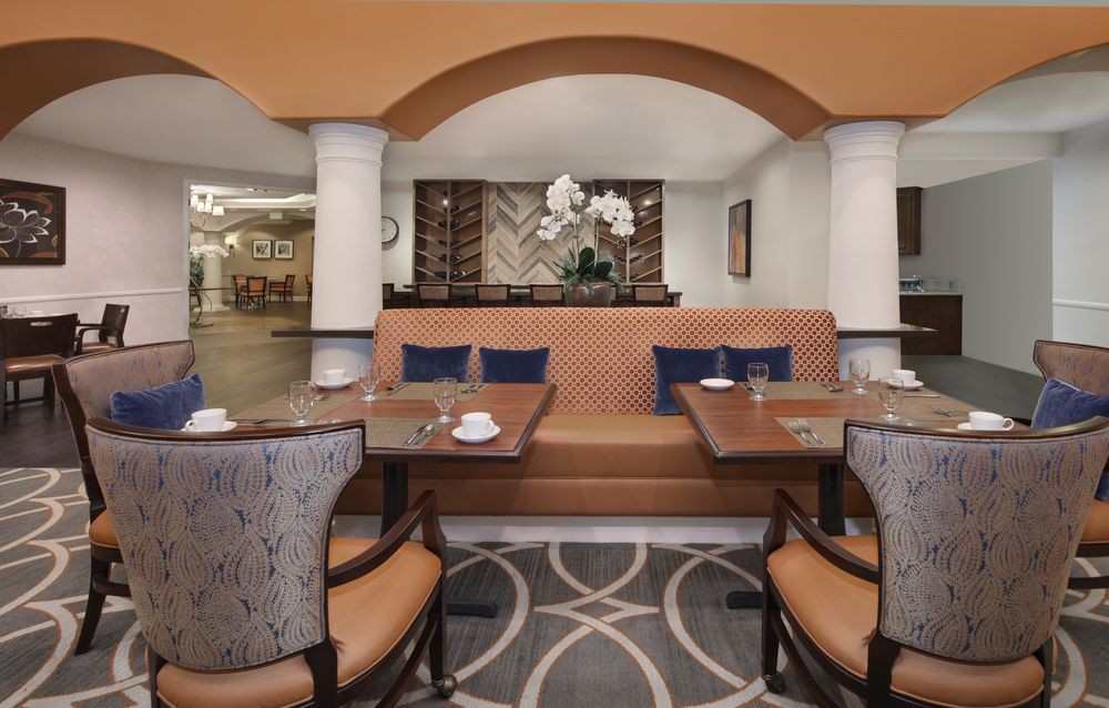 A cozy restaurant interior featuring a set of tables and chairs with elegant decor.