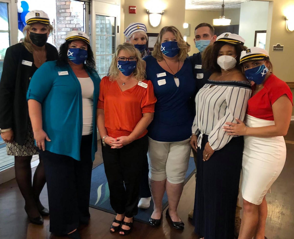 A group of people wearing masks for a casual indoor gathering.