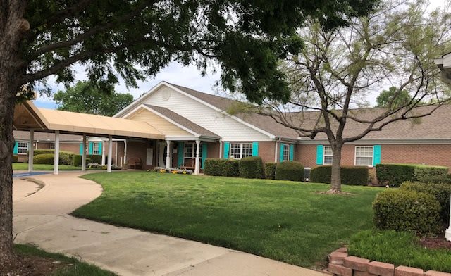 A suburban house with a well-maintained lawn and a driveway leading to the entrance.