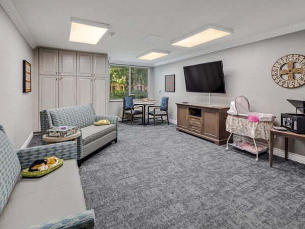 A cozy, modern living room with a sofa, television, and dining table.
