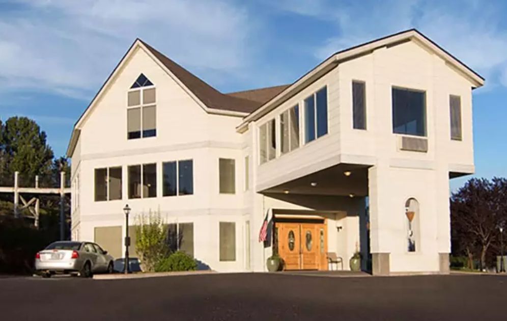 A modern building with large windows and a wooden entrance.
