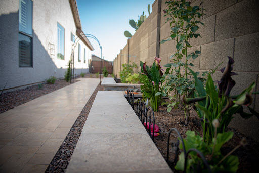 A serene garden pathway lined with vibrant flowers and plants, leading towards the home.