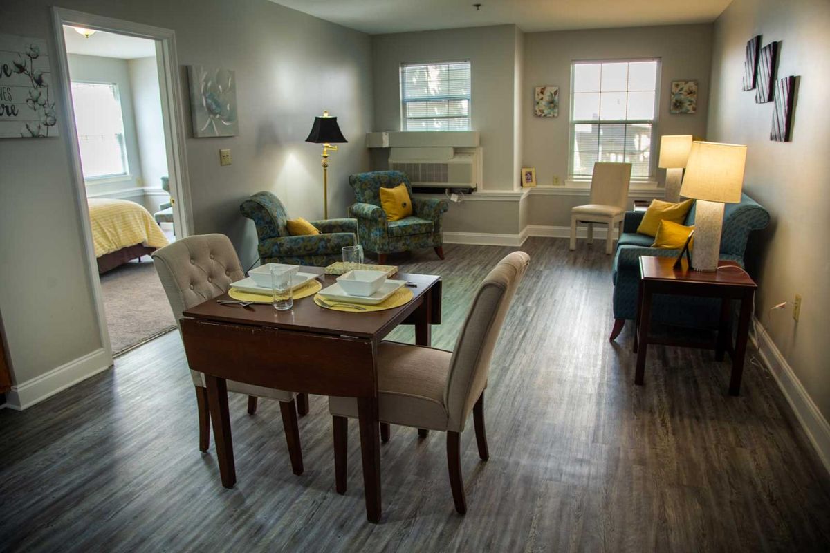 A cozy living room with a dining area, featuring comfortable seating and warm lighting.
