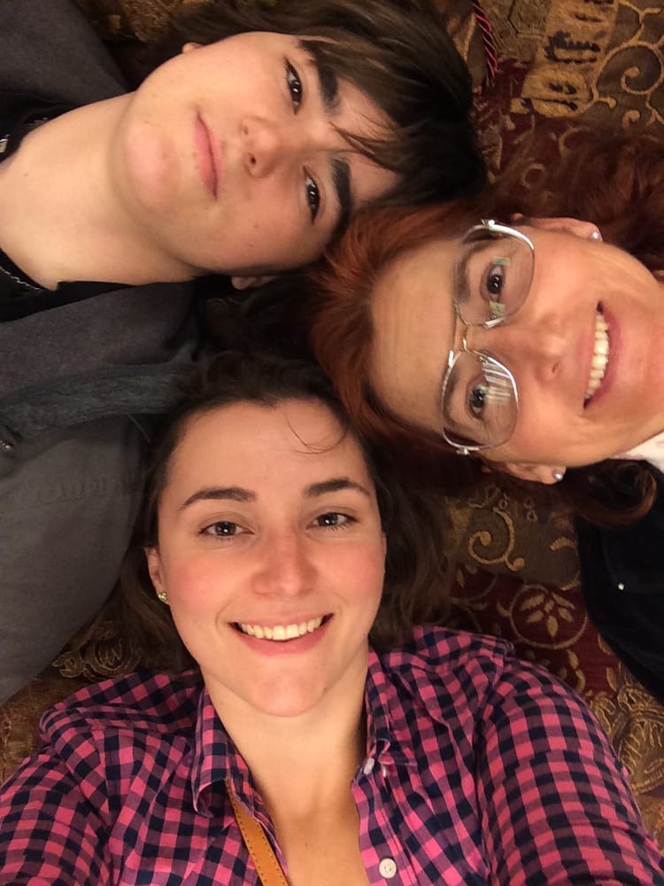 A group of friends lying down, smiling for a selfie.
