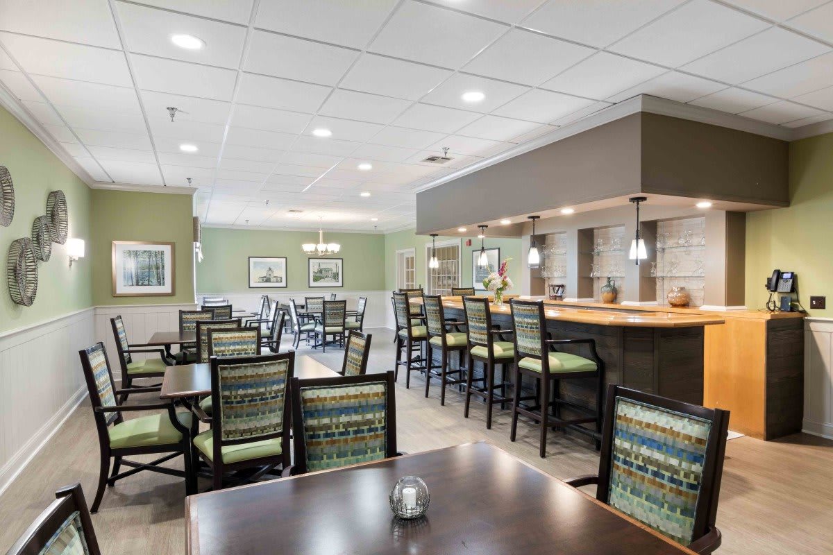 A modern restaurant interior featuring a bar and dining area with stylish seating.