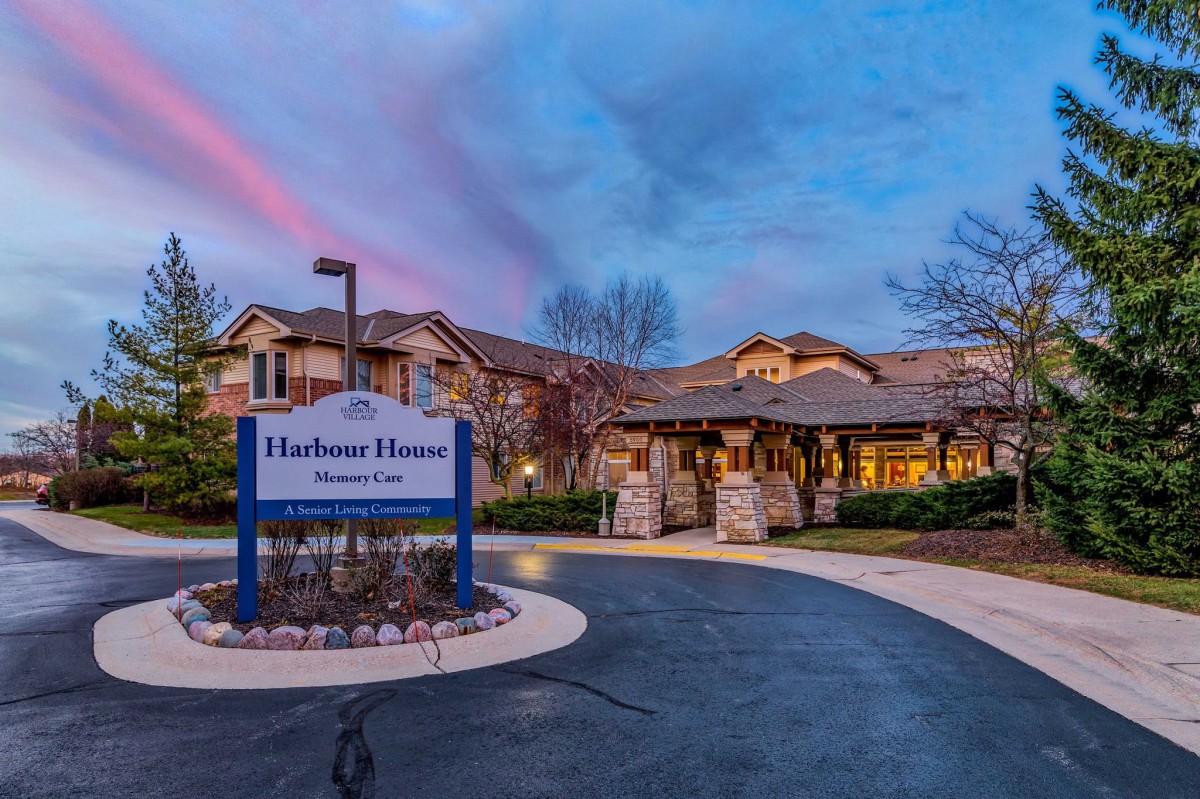 A retirement home at dusk with a welcoming entrance and signage.
