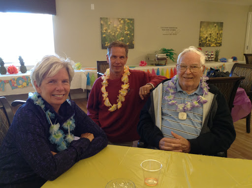 A joyful gathering with friends and family, celebrating with leis and smiles.