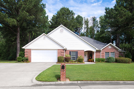 A charming single-story brick home with a well-maintained front yard and garage.