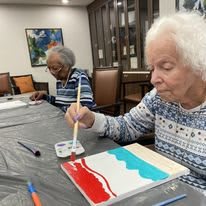 Seniors engaged in a creative painting session indoors.