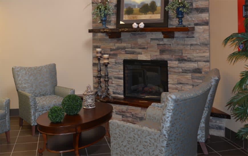 A cozy living room with a stone fireplace, plush seating, and elegant decor.