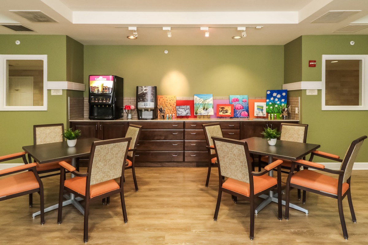 A cozy breakfast area with tables, chairs, and beverage machines.
