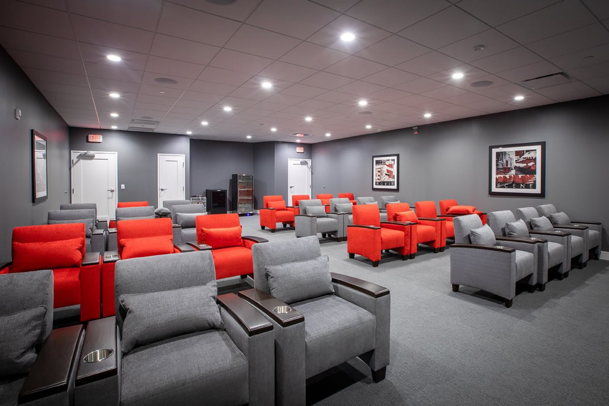A modern home theater room with red and gray seating arrangements.