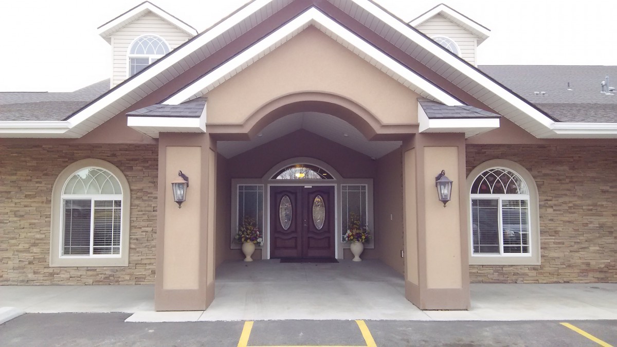 A welcoming entrance with a porch and double doors.