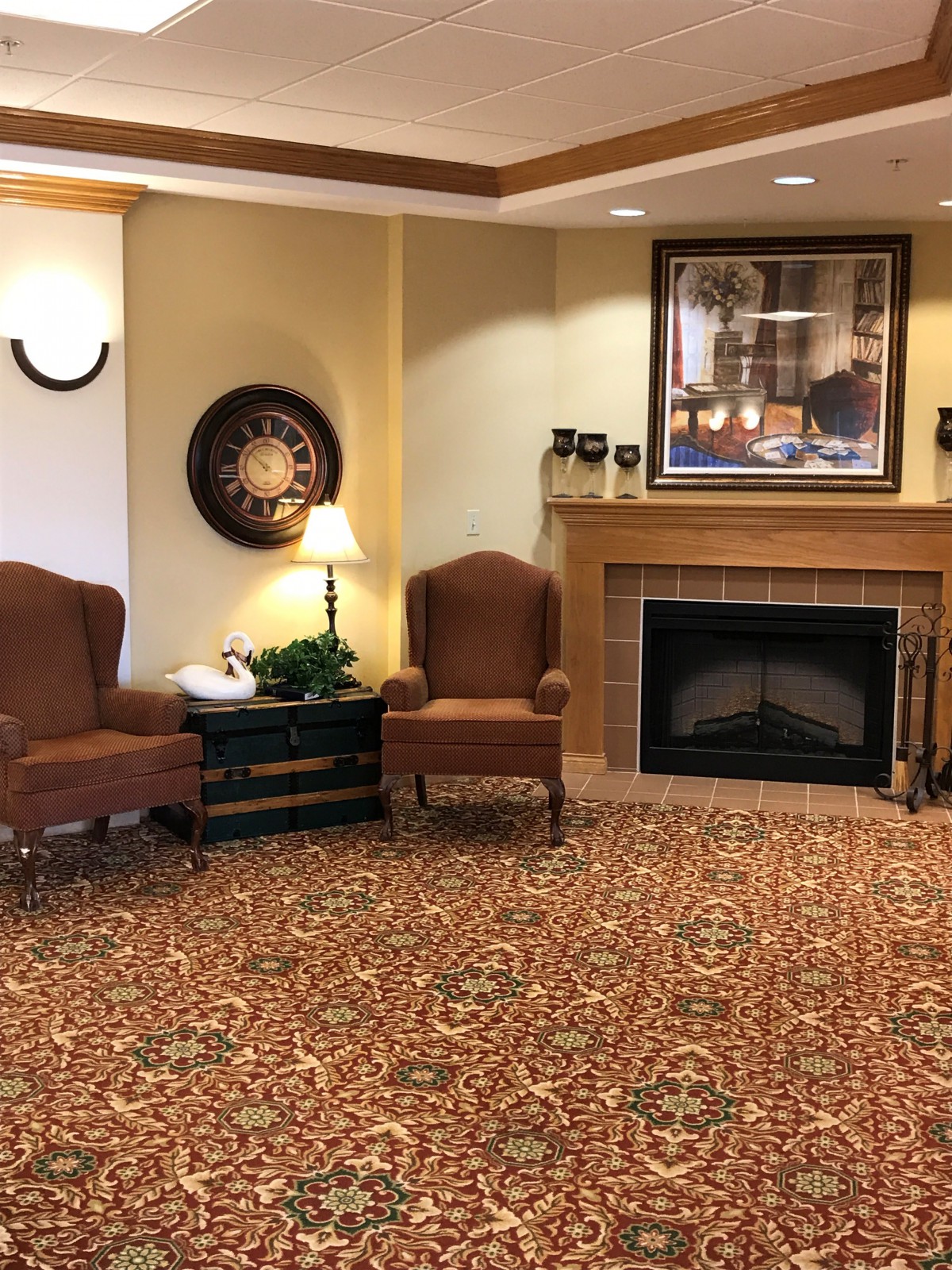 A cozy living room with a fireplace, two armchairs, and elegant decor.