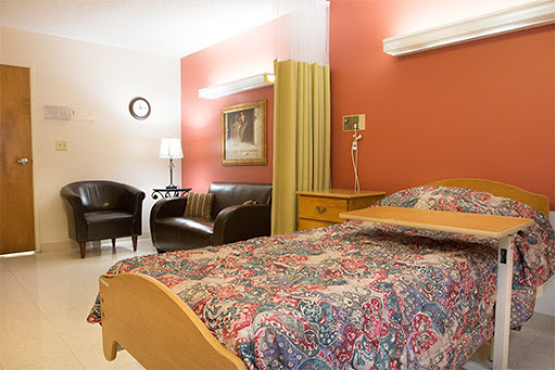 A cozy hotel room featuring a bed, seating area, and warm decor.