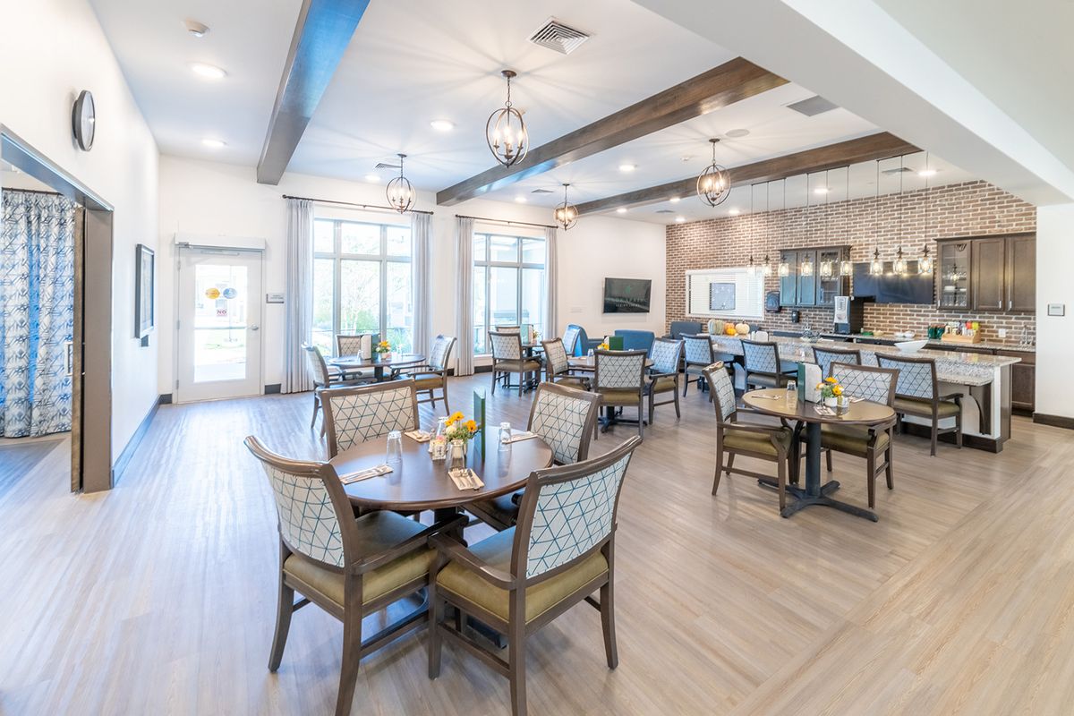 A spacious and modern dining area with elegant furniture and soft lighting.