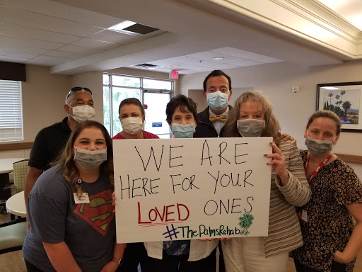 A group of caregivers holding a sign expressing their commitment to support loved ones.