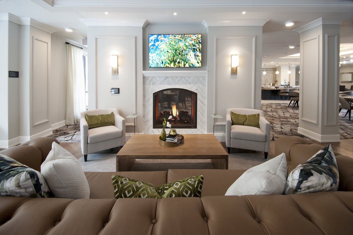 A modern living room with a cozy fireplace, stylish seating, and elegant decor.