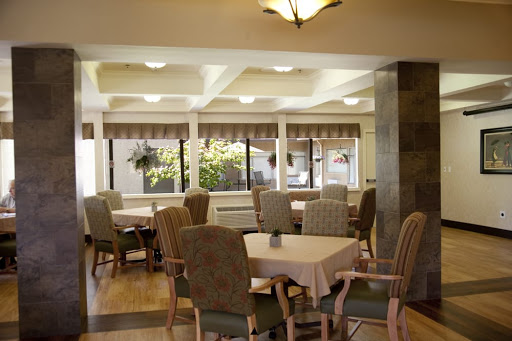 A cozy dining area filled with comfortable seating and large windows allowing natural light to illuminate the space.