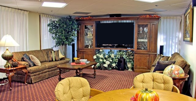 A cozy living room featuring a large television, couch, coffee table, and elegant decor.