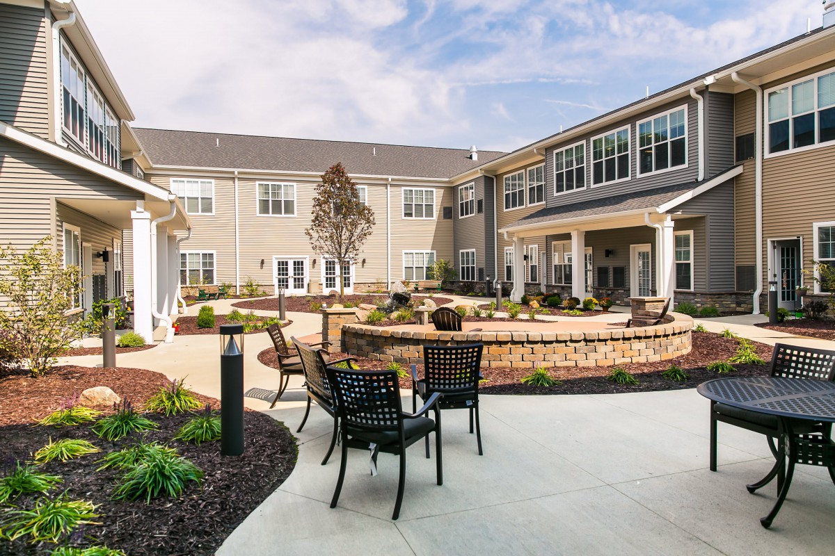 A well-maintained courtyard with seating and landscaping outside a residential building.