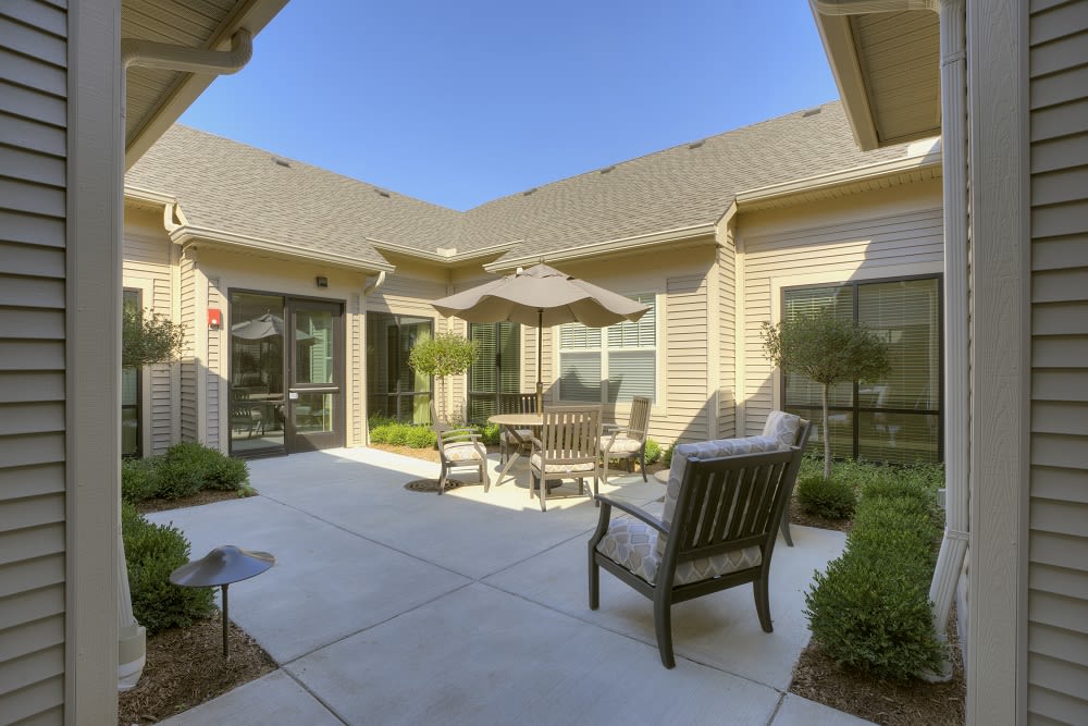 A sunny courtyard with comfortable outdoor seating and umbrellas.