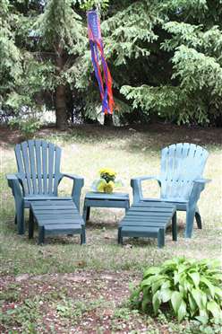 A cozy outdoor seating area with two chairs and a table, set in a lush garden.