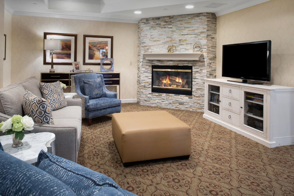 A modern living room featuring a stone fireplace and comfortable seating.