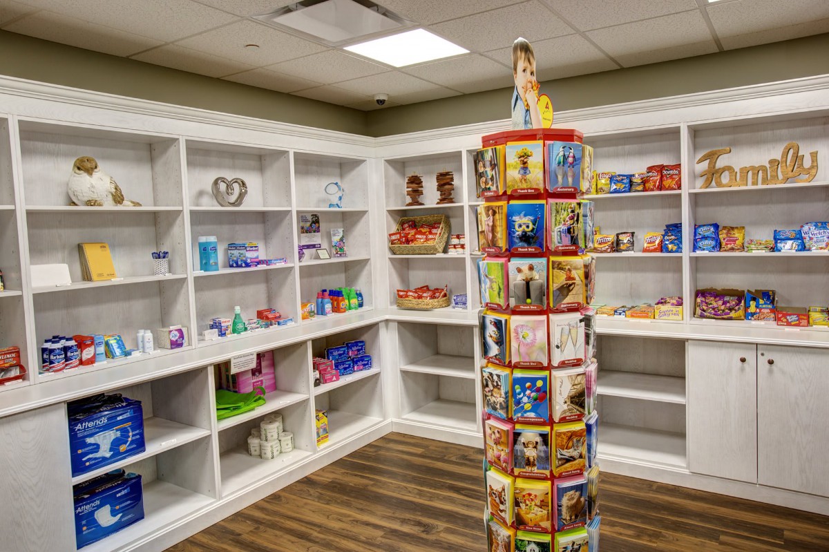 A toy store interior with shelves filled with various toys and a rotating display stand in the center.