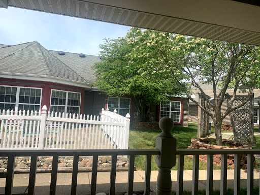 A peaceful view of a residential home with a white picket fence and a tree in the front yard.