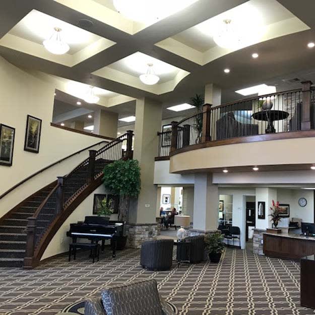 A spacious and modern lobby with a staircase and comfortable seating area.
