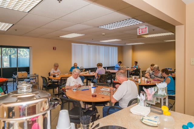Elderly individuals dining in a casual, indoor setting.