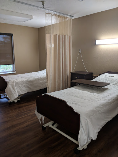 A serene patient room in a healthcare facility, featuring two beds and a calming interior.