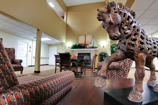 A cozy lobby featuring a wooden horse sculpture, comfortable seating, and a fireplace.