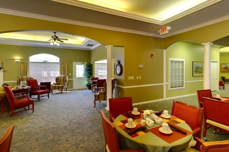 A cozy interior featuring a dining area with a neatly set table and comfortable living space in the background.