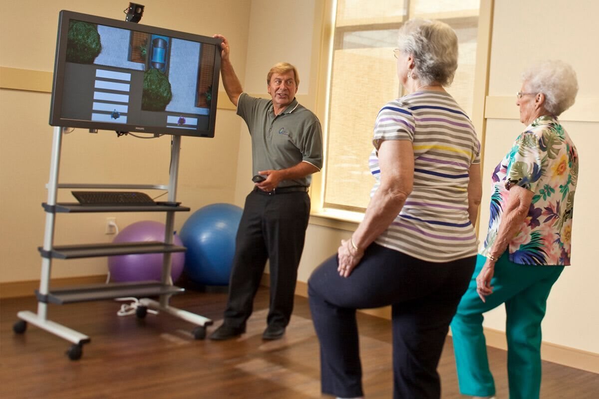 Older adults participate in a fitness class focusing on balance and physical therapy exercises.