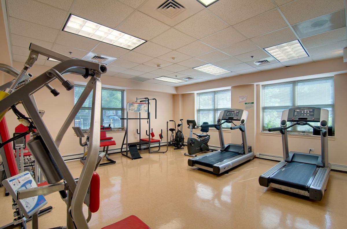 A well-equipped gym with various exercise machines, including treadmills and weightlifting equipment.