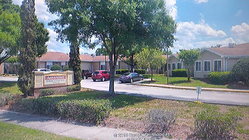 A peaceful residential community with well-maintained landscaping and vehicles parked along the street.