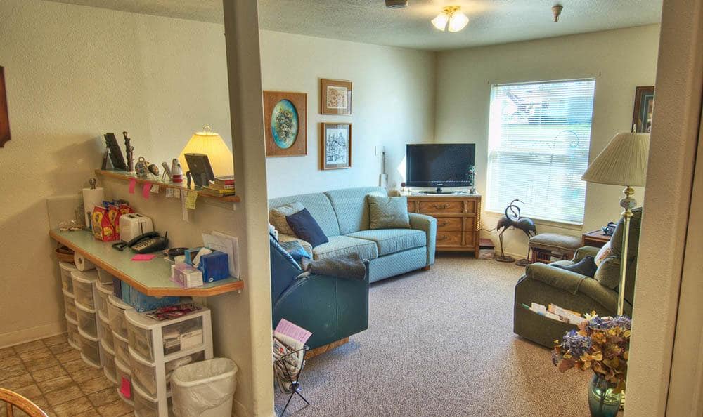 A cozy living room featuring a sofa, television, and artwork on the walls.