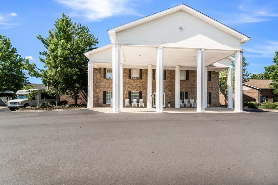 A hotel building with large white columns and a spacious entrance area, set against a clear blue sky.