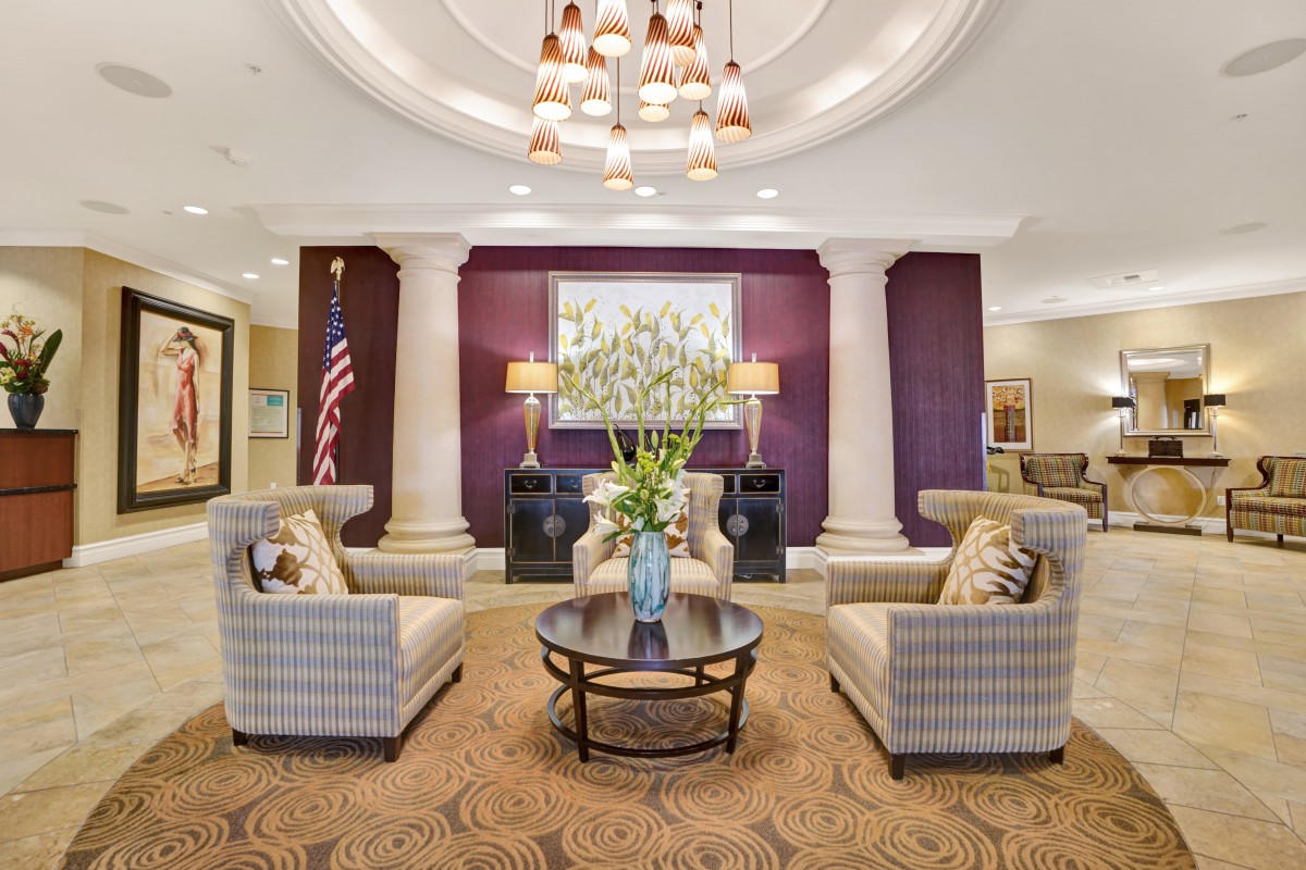 A luxurious lobby with elegant seating, chandeliers, and floral decor.