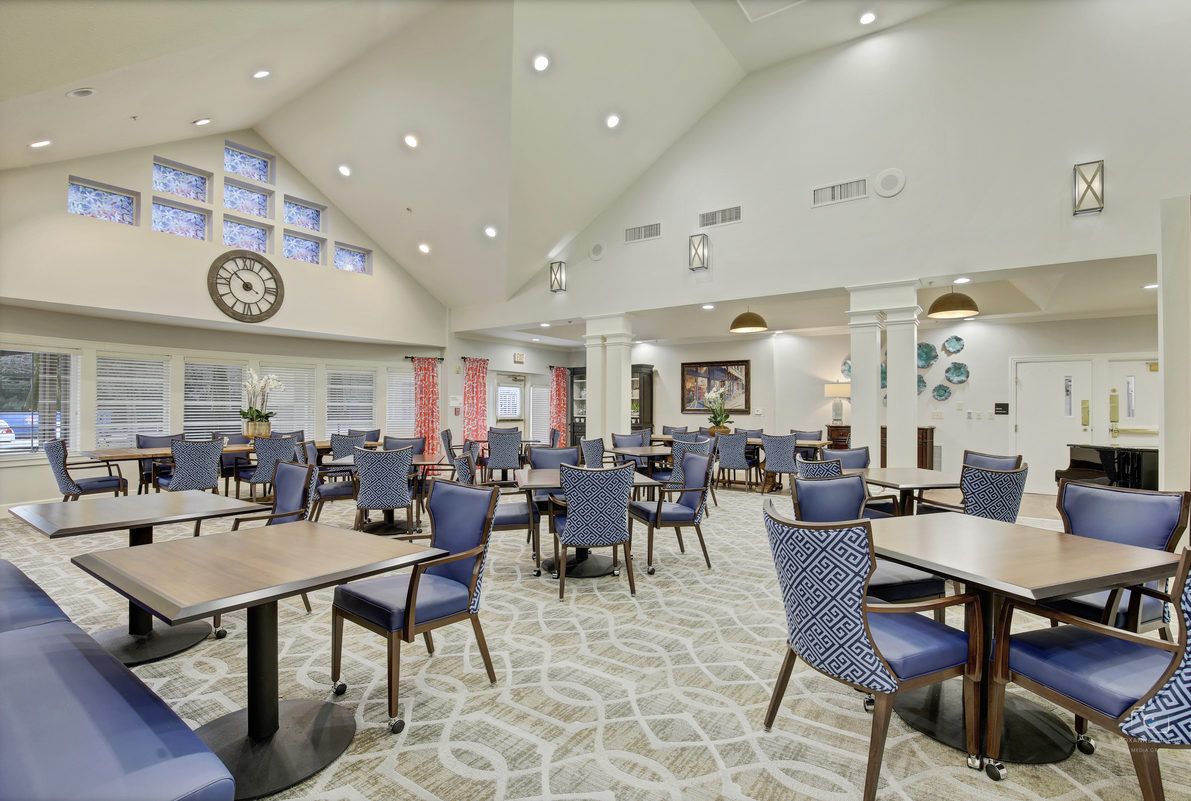 A spacious and modern dining room with elegant furniture and decorative lighting.
