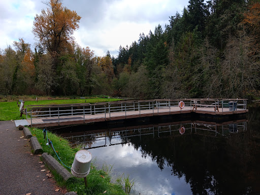 A tranquil view of a bridge over a lake surrounded by autumn foliage.